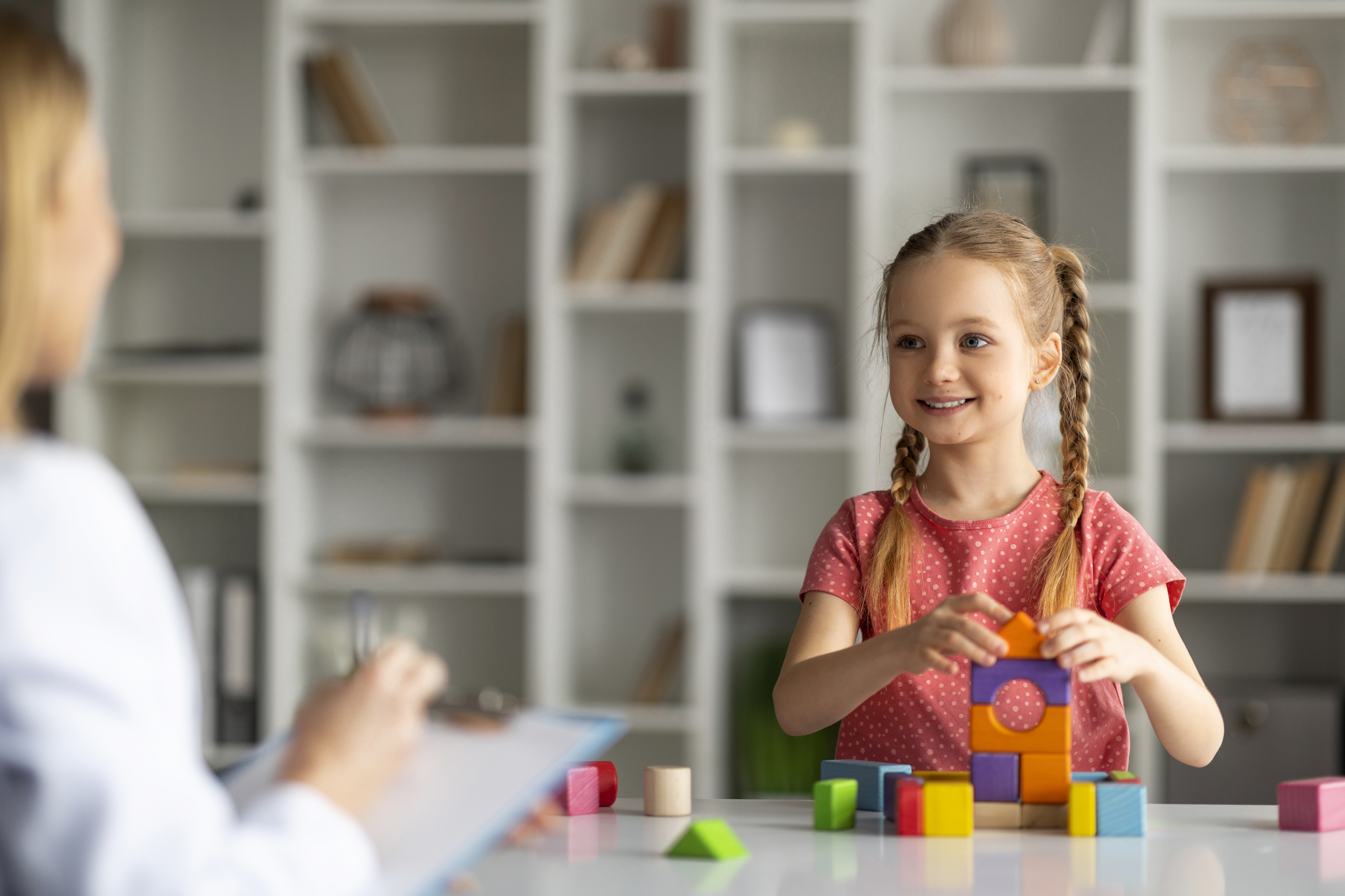 Menina sorrindo durante sessão de avaliação do desenvolvimento infantil