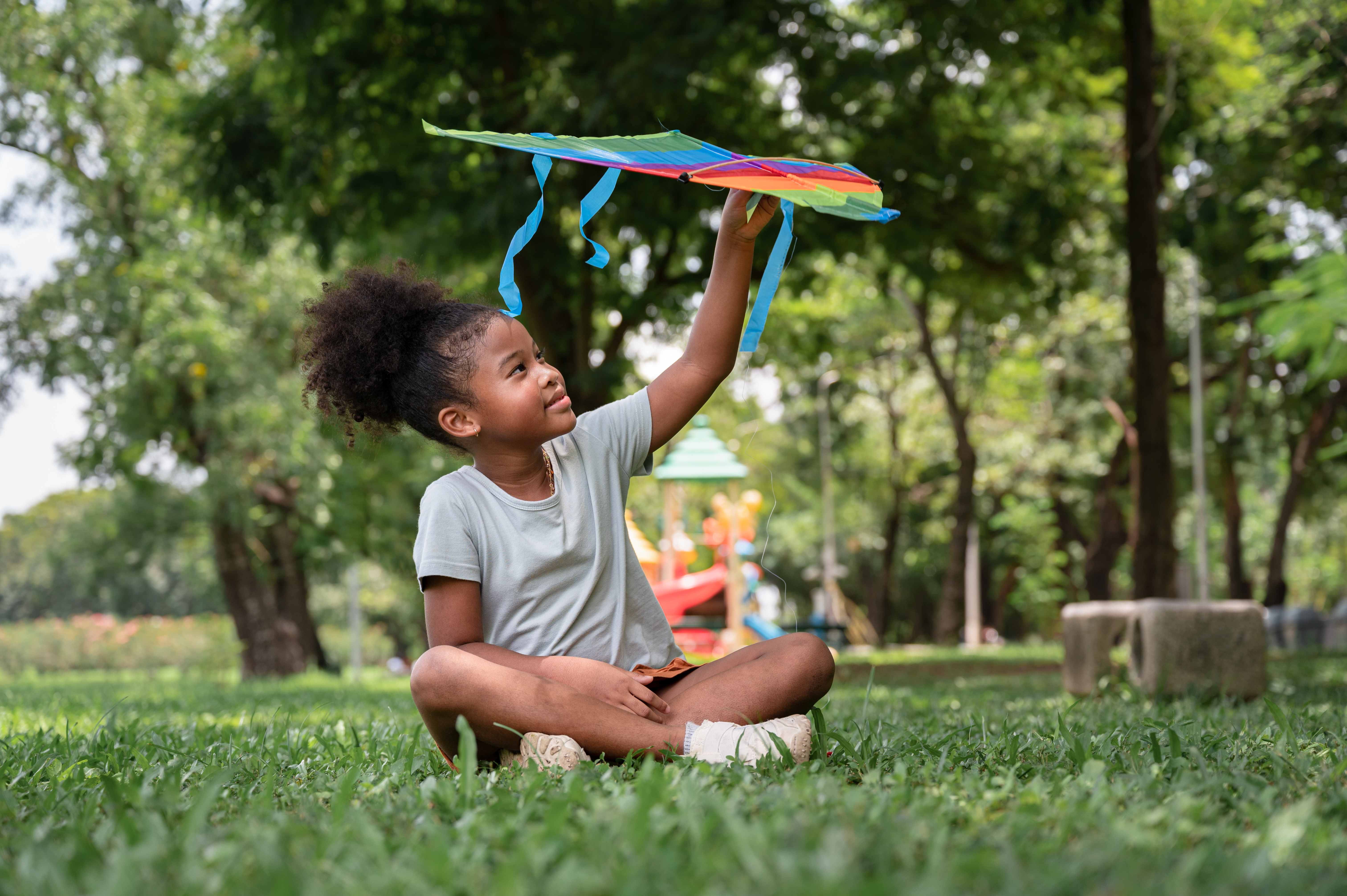 Menina brincando com pipa no parque